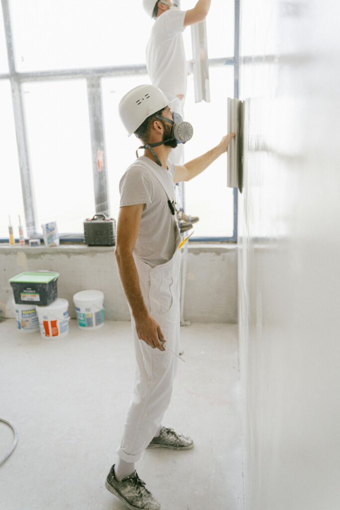 Profesionales alisando y renovando una pared interior