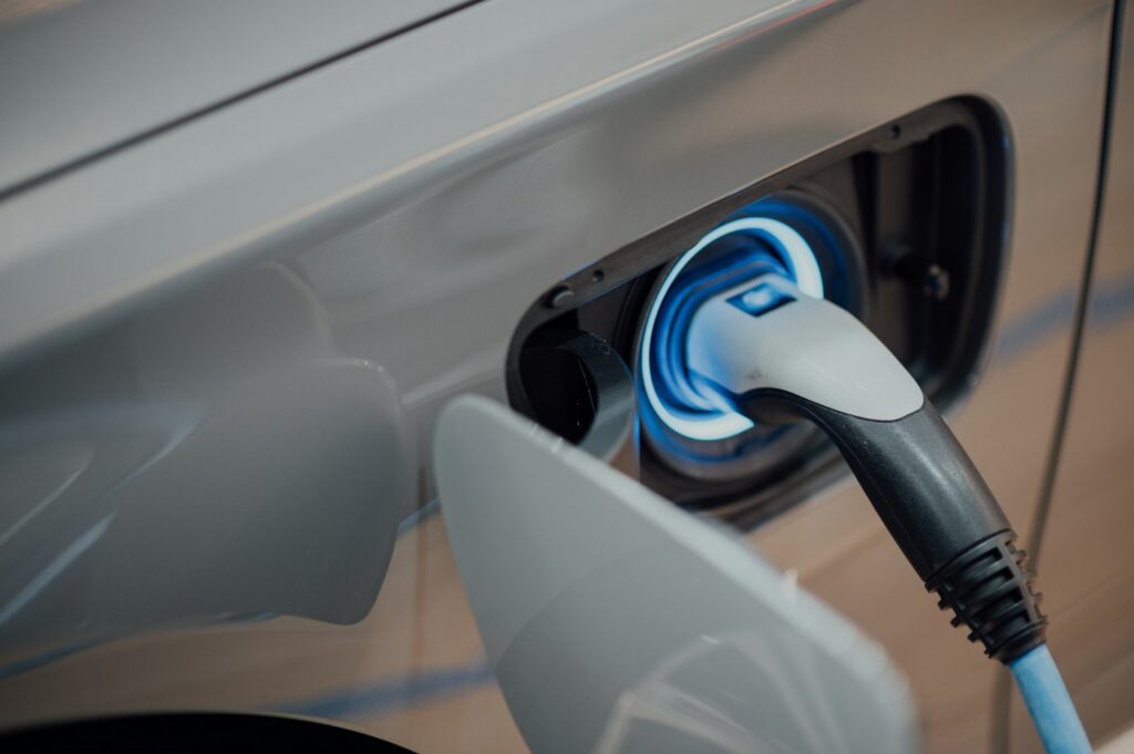 Coche eléctrico conectado a un punto de recarga en el aparcamiento
