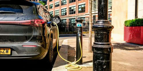 Coche eléctrico cargando en una estación de recarga urbana