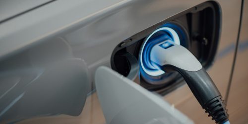Coche eléctrico conectado a un punto de recarga en el aparcamiento