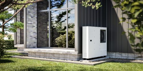 Unidad exterior de aerotermia junto a una vivienda moderna