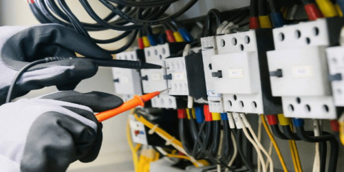 Electricista revisando un cuadro eléctrico de una instalación