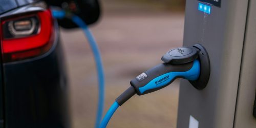 Vehículo eléctrico conectado a un punto de recarga en aparcamiento