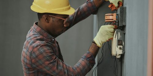 Electricista revisa un cuadro y una instalación eléctrica de empresa