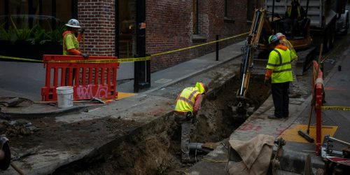 Trabajadores excavando una zanja urbana para una obra de infraestructura