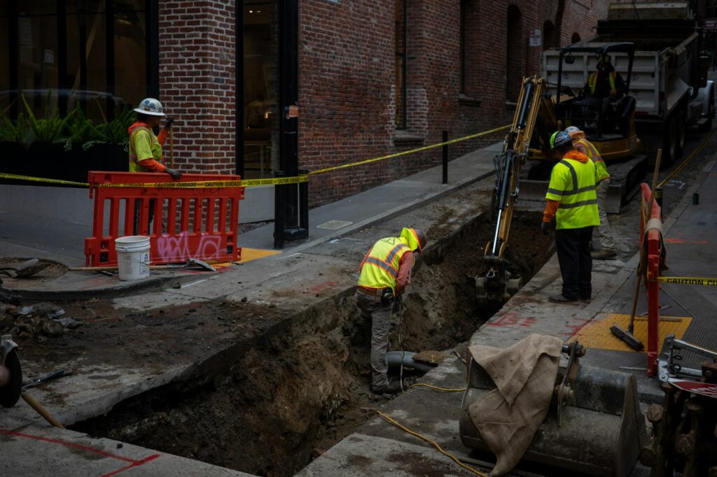 Trabajadores excavando una zanja urbana para una obra de infraestructura
